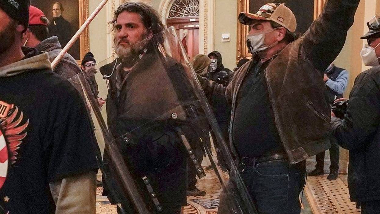 U.S. Capitol Police officers confront rioters, including Dominic Pezzola, center with police shield, outside the Senate Chamber inside the Capitol, Wednesday, Jan. 6, 2021, in Washington.