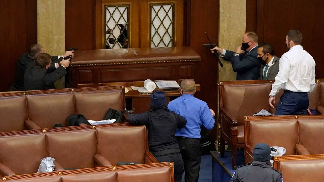 U.S. Capitol police officers protect barricaded members of the U.S. House from an attack by supporters of then-President Donald Trump on January 06, 2021.