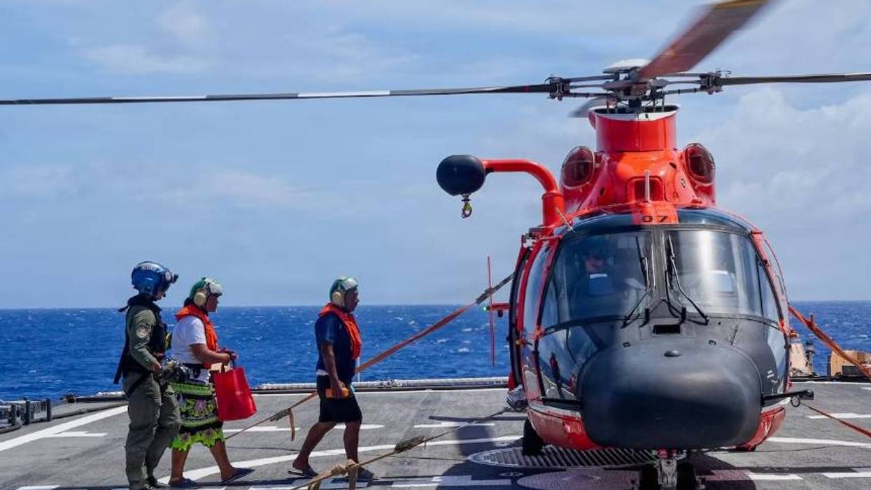U.S. Coast Guard Petty Officer 3rd Class James Warguez, an aviation maintenance technician assigned to Air Station Barber’s Point, escorts members of a local family to a U.S. Coast Guard MH-65 Dolphin helicopter embarked on Legend-class cutter USCGC Midgett (WMSL 757) for further transport to Weno, Federated States of Micronesia, on April 6, 2026.