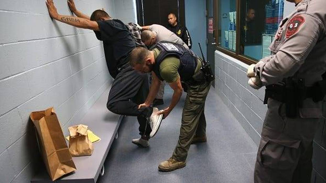 U.S. Immigration and Customs Enforcement (ICE), agents frisk a detained immigrant at a processing center on October 14, 2015 in Camarillo, California. ICE builds deportation cases against thousands of both undocumented and Green Card holding immigrants co