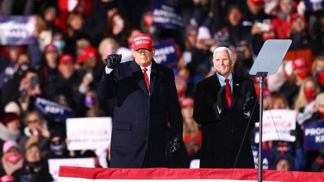 U.S. President Donald Trump (L) and U.S. Vice President Mike Pence (R) greet supporters at a rally on November 2, 2020 in Traverse City, Michigan.
