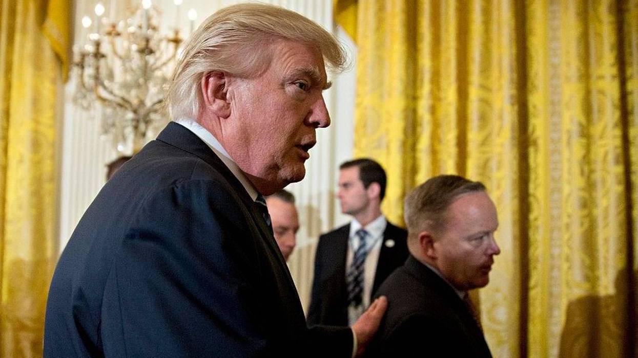 U.S. President Donald Trump walks out with Sean Spicer, White House press secretary (R) during a swearing in ceremony of White House senior staff in the East Room of the White House on January 22, 2017 in Washington, DC.
