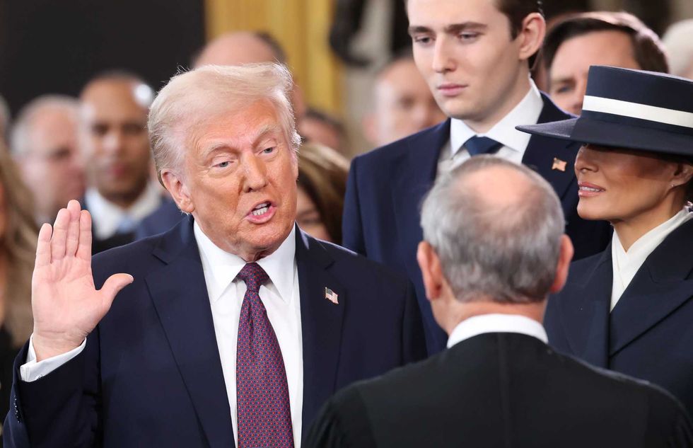 U.S. President-elect Donald Trump takes the oath of office as Barron Trump and Melania Trump look on during inauguration ceremonies in the U.S. Capitol Rotunda on January 20, 2025 in Washington, DC. Donald Trump takes office for his second term as the 47th president of the United States. (Photo by Kevin Lamarque - Pool/Getty Images)