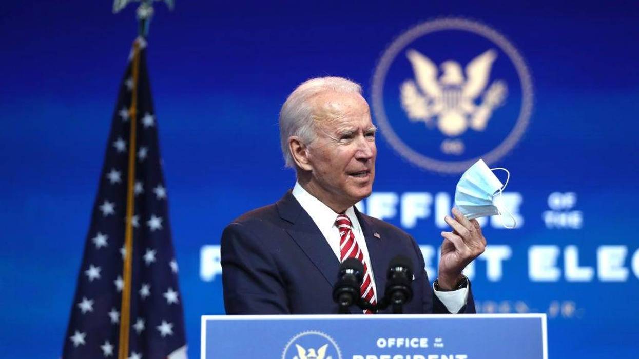 U.S. President-elect Joe Biden holds up a face mask as he delivers remarks