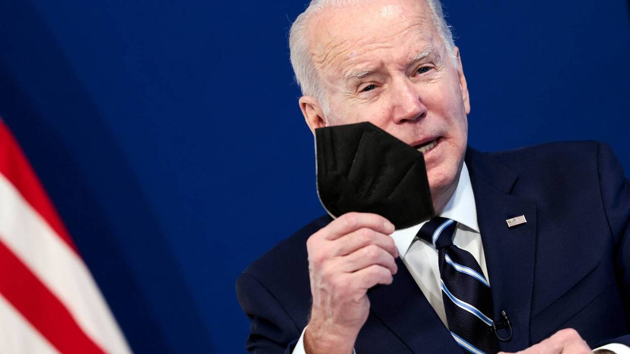 U.S. President Joe Biden holds a mask as he gives remarks on his administration's response to the surge in COVID-19 cases across the country
