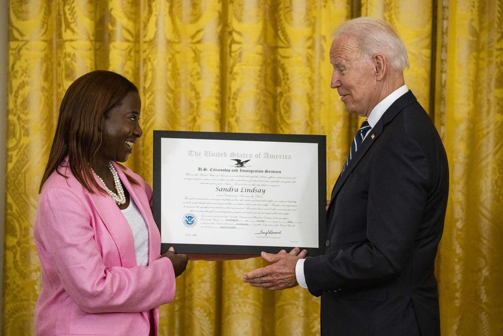 U.S. President Joe Biden presents Sandra Lindsay, a naturalized American Citizen and nurse who was first to receive the Covid-19 vaccine outside of trials, with the Outstanding American by Choice Award from the U.S. Citizen and Immigration Services during a naturalization ceremony in the East Room of the White House in Washington, D.C., U.S., on Friday, July 2, 2021. The ceremony is to welcome citizens to the United States ahead of Independence Day.