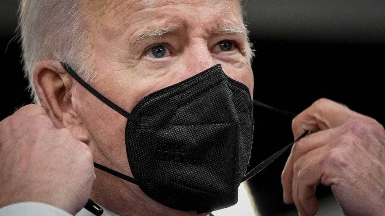 U.S. President Joe Biden removes his face mask as he arrives to sign H.R. 3537, the Accelerating Access to Critical Therapies for ALS Act in the South Court Auditorium of the White House complex December 23, 2021 in Washington, DC.
