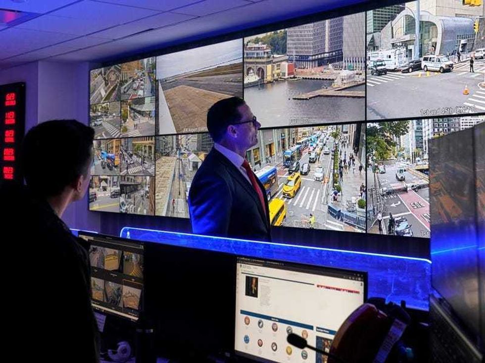 U.S. Secret Service Special Agent in Charge Matt McCool, center, looks at live video surveillance feeds in the agency