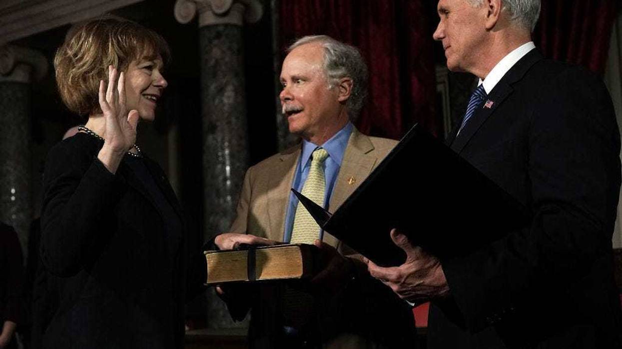 U.S. Sen. Tina Smith (D-MN) and her husband Archie Smith participate in a mock swearing-in ceremony with Vice President Mike Pence at the Old Senate Chamber of the U.S. Capitol January 3, 2018 in Washington, DC.