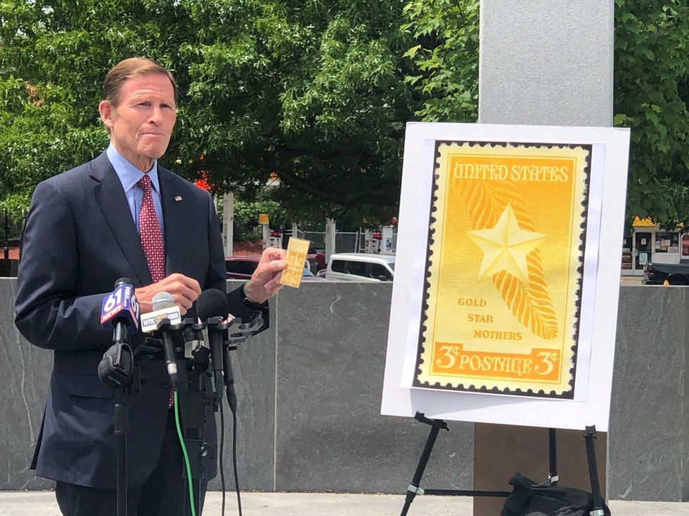 U.S. Senator Richard Blumenthal holds the original Gold Star Mothers postal stamp which sold for 3 cents.