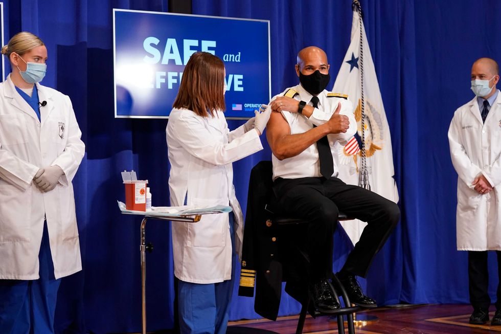 U.S. Surgeon General Jerome Adams receives a Pfizer-BioNTech COVID-19 vaccine shot at the Eisenhower Executive Office Building on the White House complex, Friday, Dec. 18, 2020, in Washington.