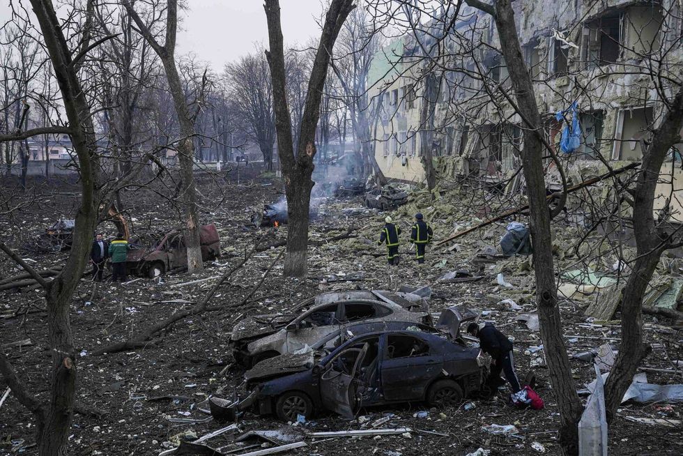Ukrainian emergency employees work at the side of the damaged by shelling maternity hospital in Mariupol, Ukraine, Wednesday, March 9, 2022