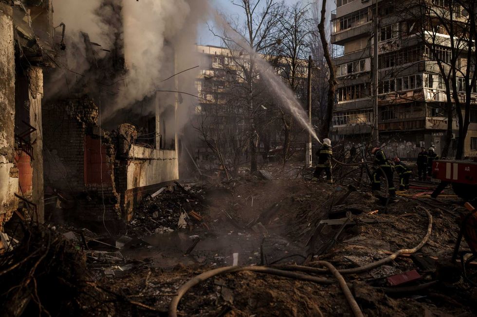 Ukrainian firefighters work in an apartment building after bombing in Kyiv, Ukraine, Tuesday, March 15, 2022