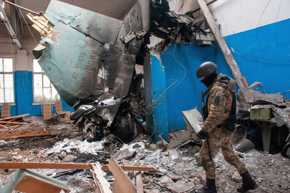 Ukrainian serviceman walks past the vertical tail fin of a Russian Su-34 bomber lying in a damaged building in Kharkiv, Ukraine, Tuesday, March 8, 2022