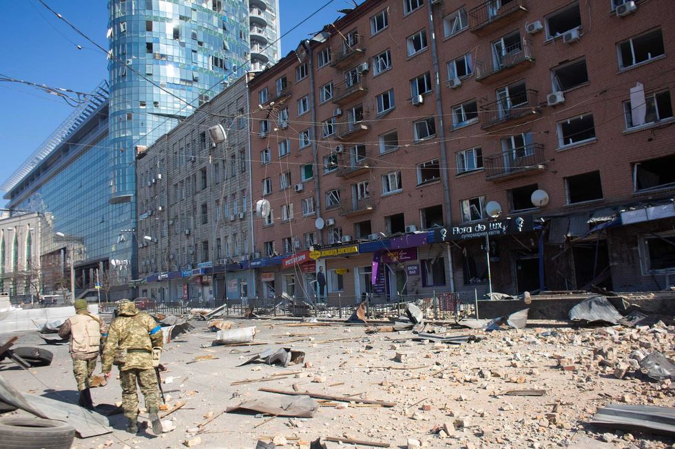 Ukrainian servicemen are seen by the building which got shelled near Lukyanivska metro station on March 15, 2022 in Kyiv, Ukraine