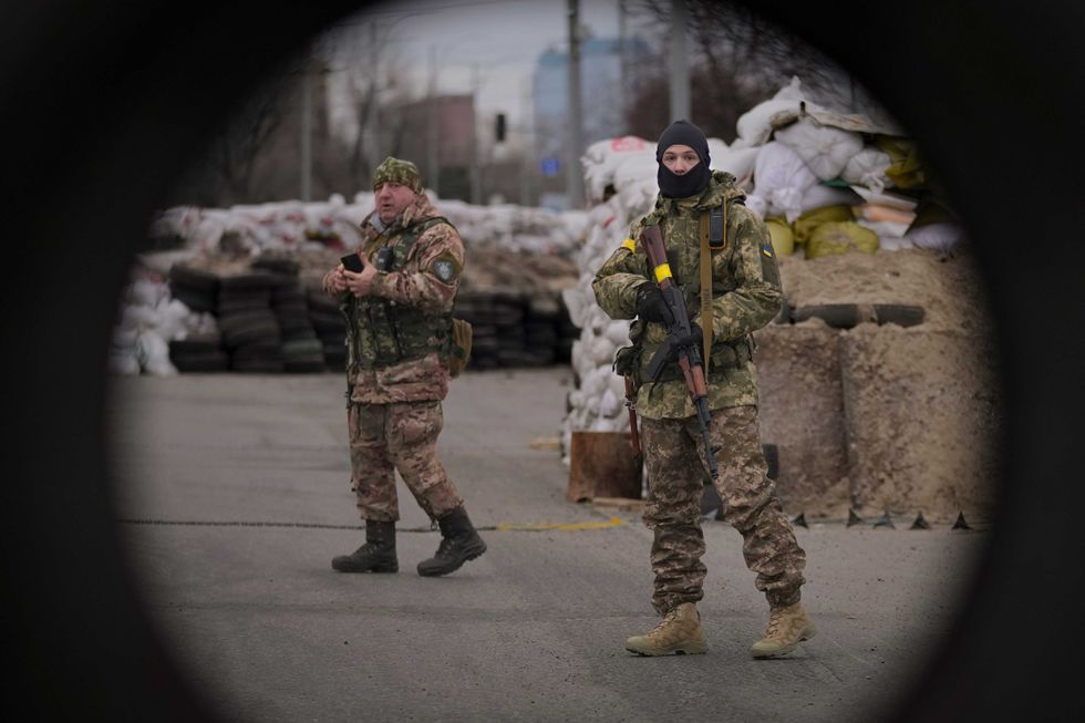 Ukrainian servicemen guard a checkpoint on a main road in Kyiv, Ukraine, Monday, March 7, 2022