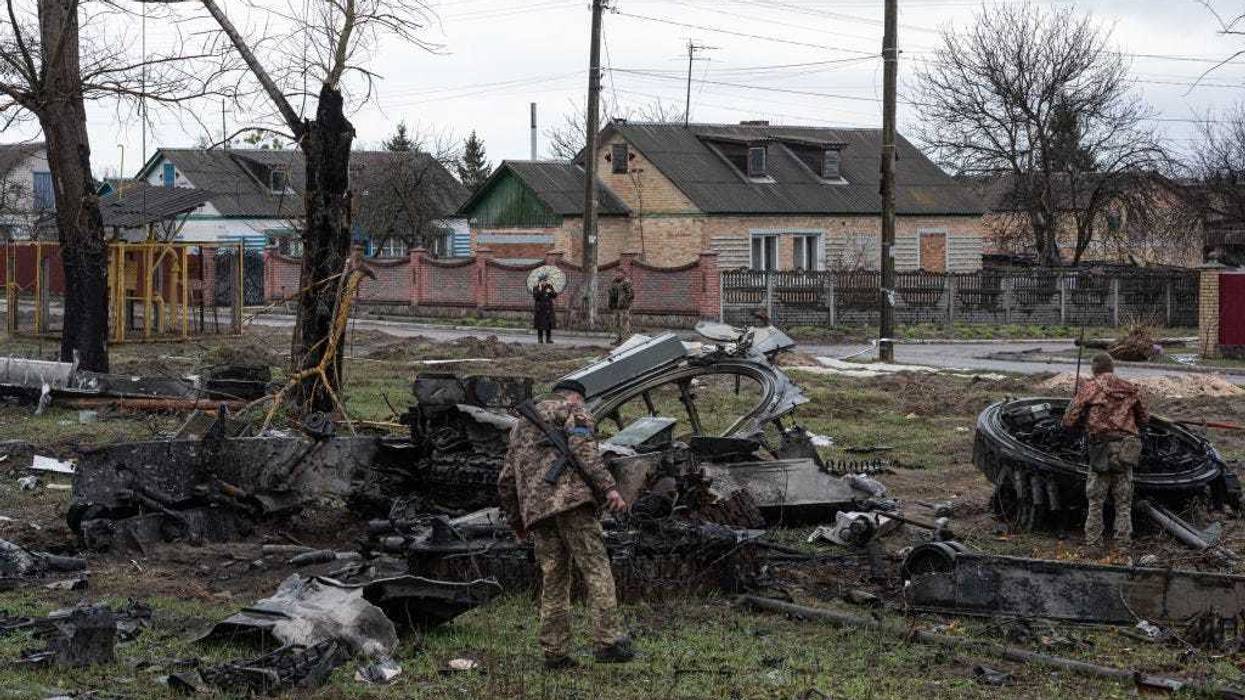 Ukrainian servicemen inspect the remains of a Russian tank by the road on April 8, 2022 in Zdvyzhivka, Ukraine.