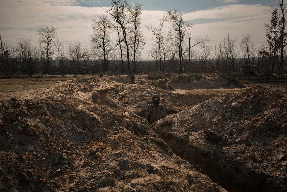 Ukrainian servicemen stand in trenches at a position north of the capital Kyiv, Ukraine, Tuesday, March 29, 2022