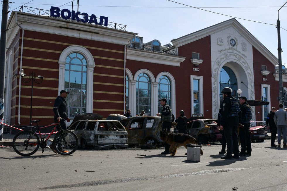 Ukrainian servicemen stand next to damaged cars after Russian shelling at the railway station in Kramatorsk, Ukraine, Friday, April 8, 2022