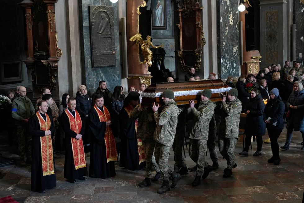 Ukrainian soldiers carry the coffin of one of the Ukrainian military servicemen, who were killed during an airstrike on a military base in Yarokiv, during a funeral ceremony in Lviv, Ukraine, Tuesday, March 15, 2022