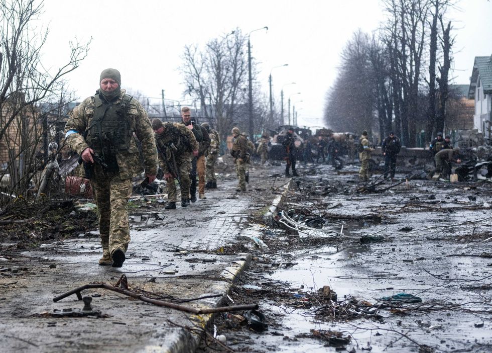 Ukrainian soldiers inspect the wreckage of a destroyed Russian armored column on a road in Bucha, a suburb just north of the Capital, Kyiv, on April 3, 2022