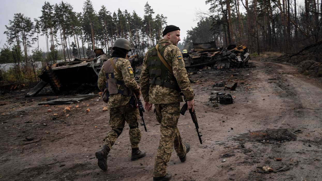 Ukrainian soldiers walk next to destroyed Russian tanks in the outskirts of Kyiv, Ukraine, Thursday, March 31, 2022. Russian forces shelled Kyiv suburbs, two days after the Kremlin announced it would significantly scale back operations near both the capital and the northern city of Chernihiv to “increase mutual trust and create conditions for further negotiations.”