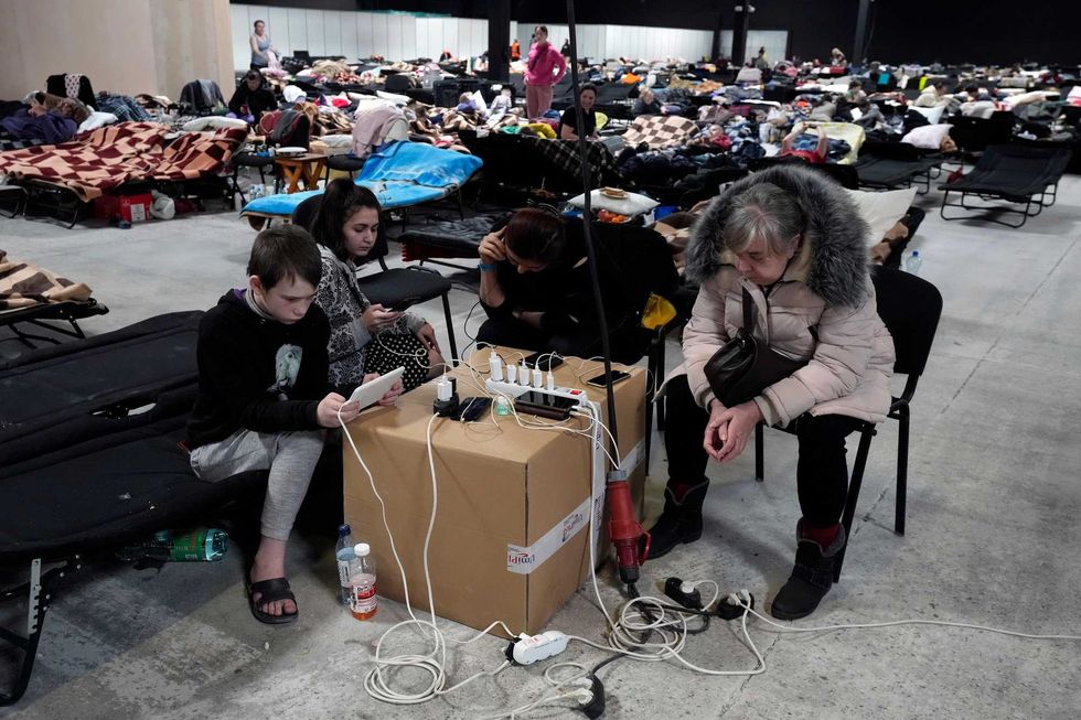 Ukrainians charge their electronic devices at a refugee shelter in Nadarzyn, near Warsaw, Poland, Thursday, March 17, 2022