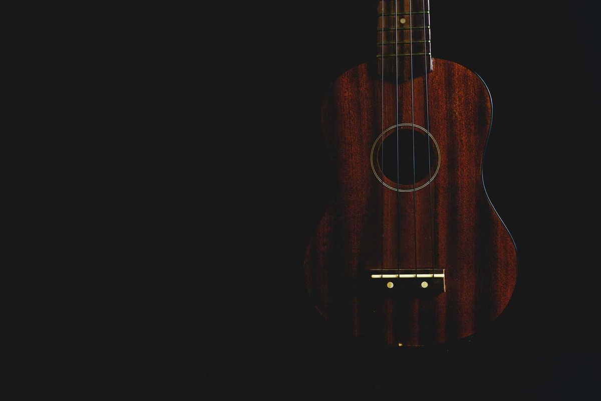 Ukulele in the shadows stock photo.