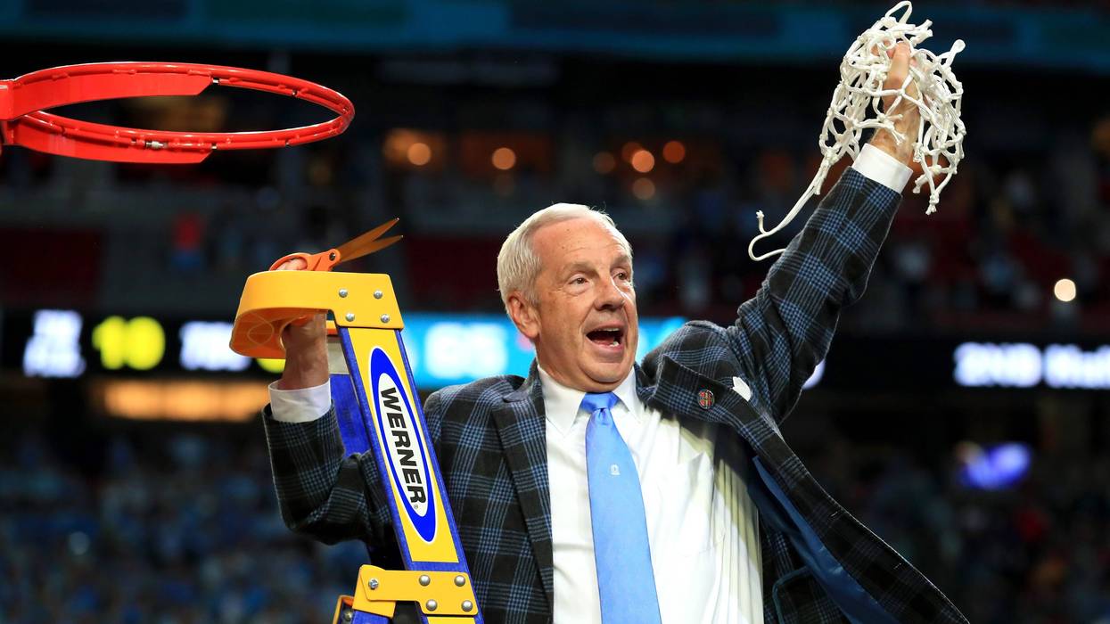 UNC head coach Roy Williams cuts down the nets.