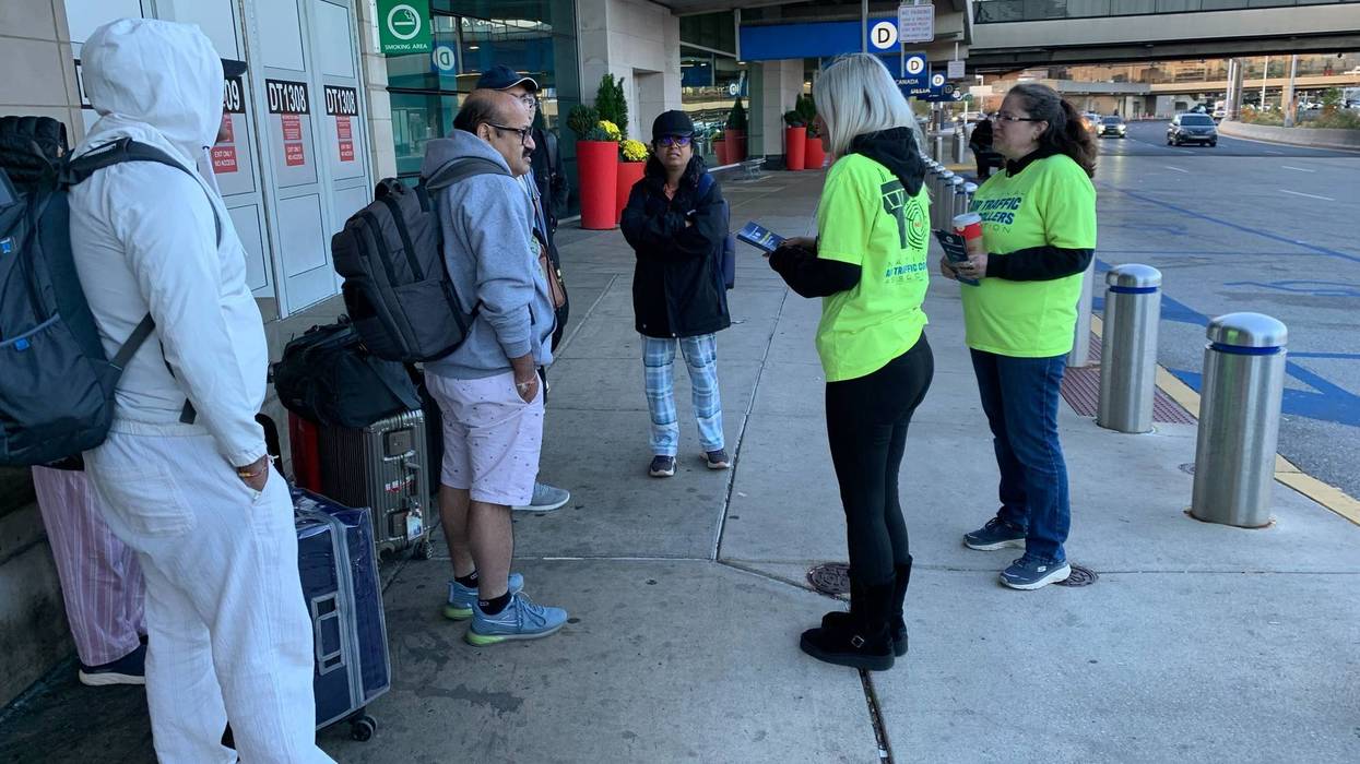 Union members at 20 airports nationwide, including Philadelphia International, distribute “end the shutdown” leaflets to travelers, highlighting shutdown-related safety concerns, on Oct. 28, 2025.