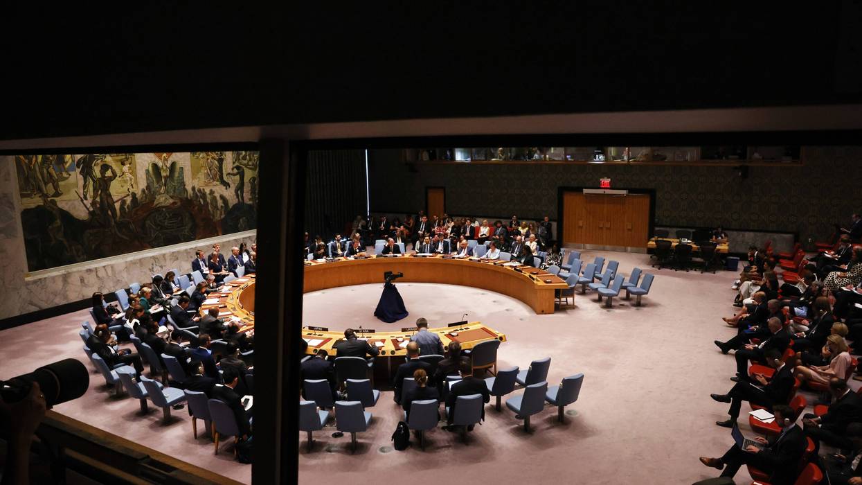 united nations members sit at horseshoe shaped desk