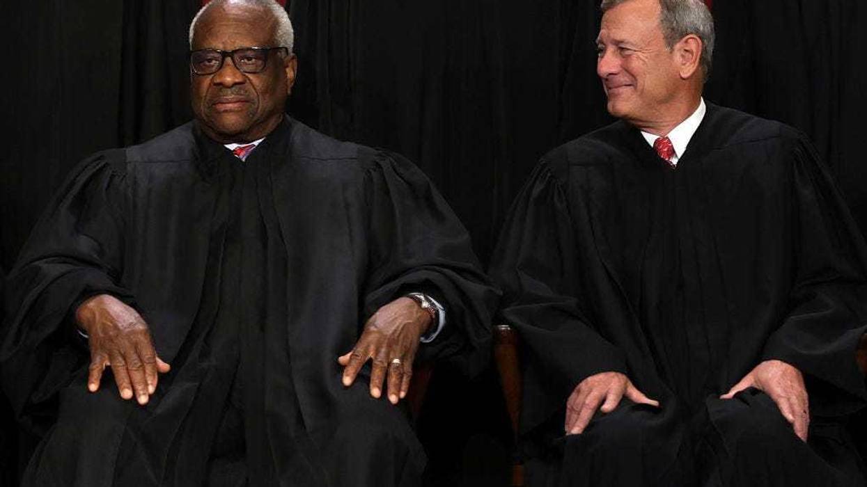 United States Supreme Court Associate Justice Clarence Thomas (L) and Chief Justice of the United States John Roberts (R) pose for their official portrait at the East Conference Room of the Supreme Court building on October 7, 2022 in Washington, DC. The Supreme Court has begun a new term after Associate Justice Ketanji Brown Jackson was officially added to the bench in September. (Photo by Alex Wong/Getty Images)