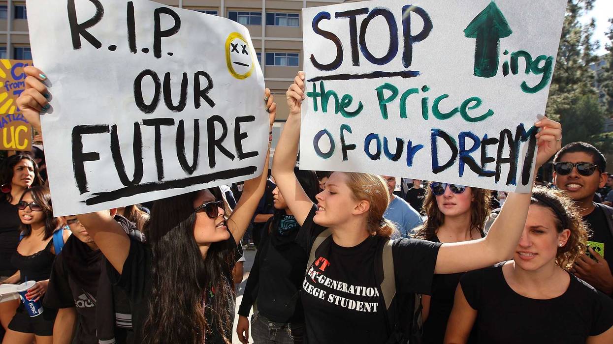 University of California Los Angeles (UCLA) students Andrea Flores (L) and Kendall Brown (R) and other UCLA students and supporters demonstrate outside the UC Board of Regents meeting where members voted to approve a 32 percent tuition hike next year on November 19, 2009 in Los Angeles, California. Undergraduate fees for students at the California university system would be increasing by about $2,500. It is the second day that demonstrators, including students from other UC campuses, have gathered to try to dissuade the board from approving the proposed increase. Massive cuts to balance the state budget have squeezed education funds in California. (Photo by David McNew/Getty Images)