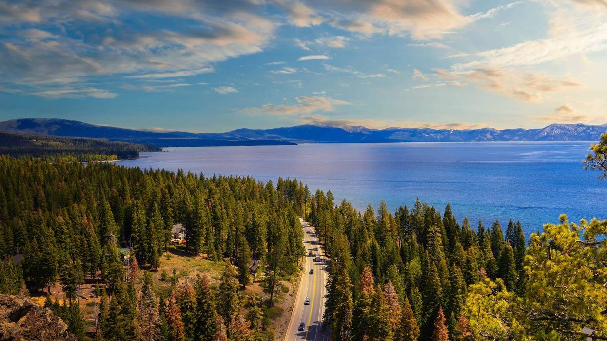 unset view from the Eagle Rock at Lake Tahoe and nearby road, California, with Sierra Nevada Mountains in the background.
