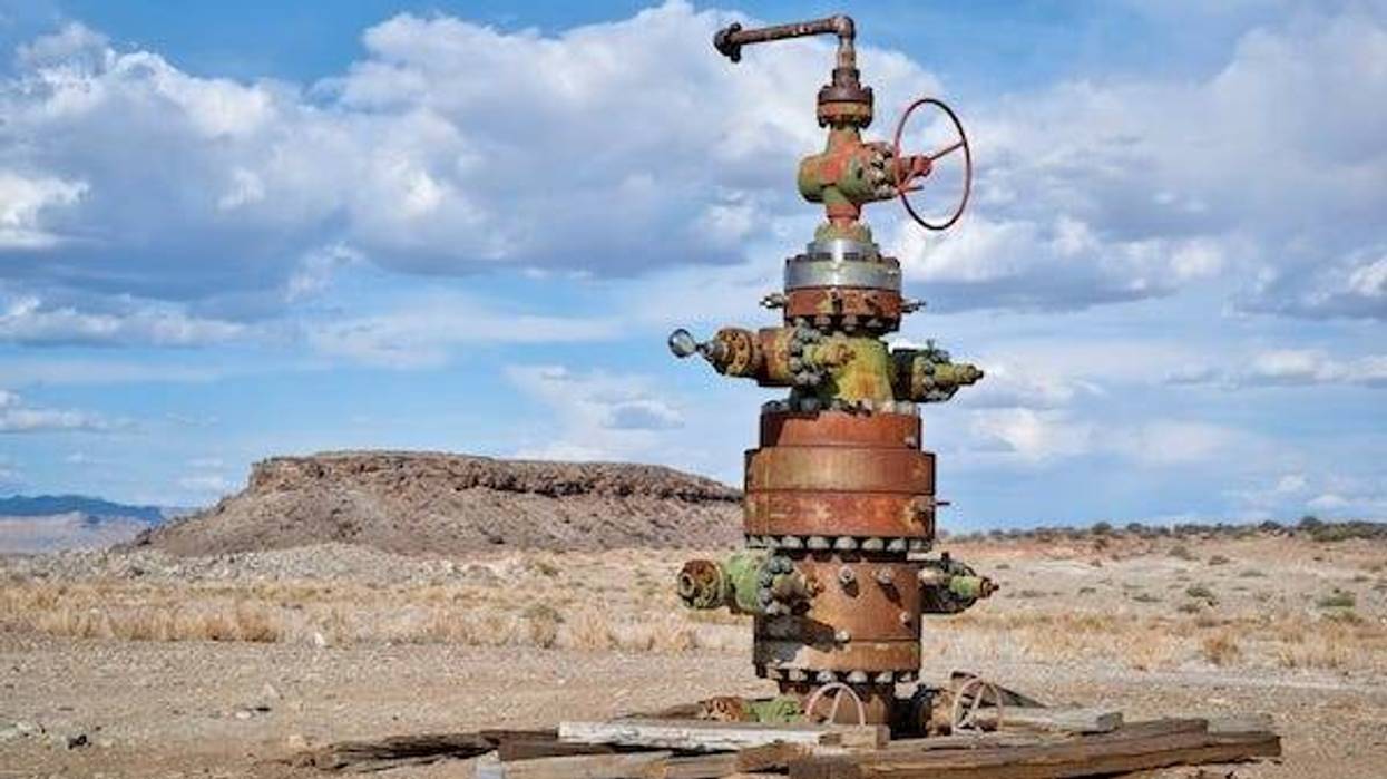 Unused head of oil well with numerous valves in a desert landscape