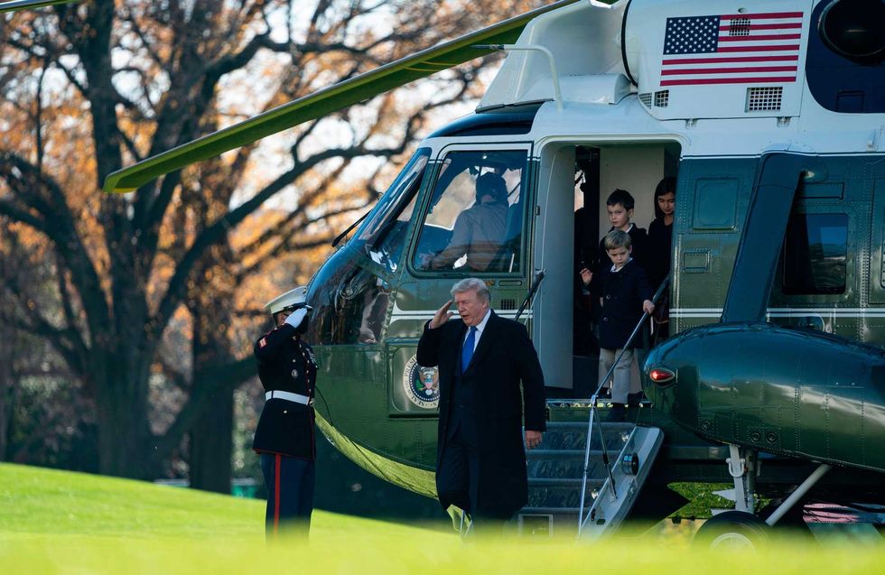 US President Donald Trump, followed by his grandchildren, Arabella, Theodore, and Joseph, arrives at the White House aboard Marine One on November 29, 2020 in Washington, DC. - President Trump spent the Thanksgiving weekend at Camp David and his Trump National Golf Course in Virginia.