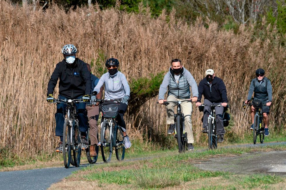 US President-elect Joe Biden (L) and his wife Jill Biden (2nd L) ride their bikes at Cape Henlopen State Park near Rehoboth Beach, Delaware, on November 14, 2020.