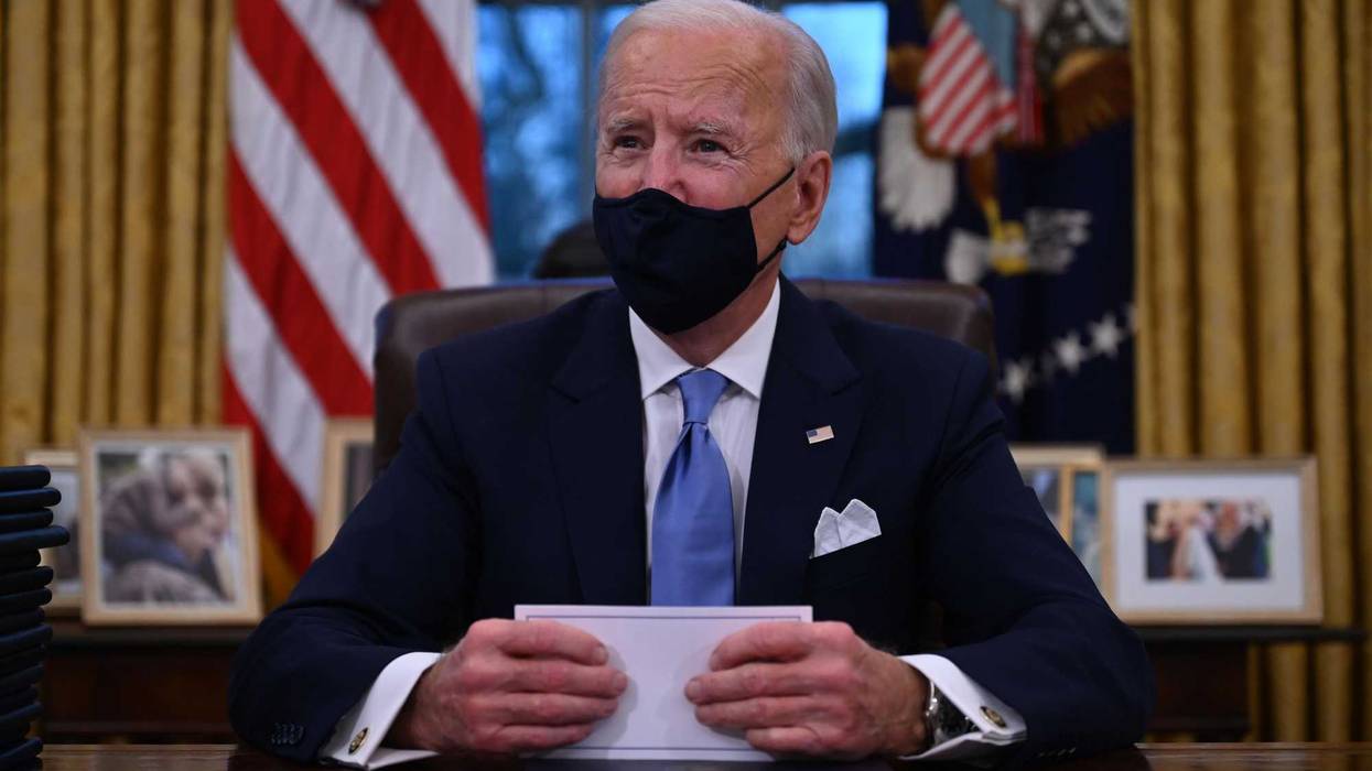 US President Joe Biden prepares to sign a series of orders in the Oval Office of the White House in Washington, DC, after being sworn in at the US Capitol on January 20, 2021. - US President Joe Biden signed a raft of executive orders to launch his administration, including a decision to rejoin the Paris climate accord. The orders were aimed at reversing decisions by his predecessor, reversing the process of leaving the World Health Organization, ending the ban on entries from mostly Muslim-majority countries, bolstering environmental protections and strengthening the fight against Covid-19.