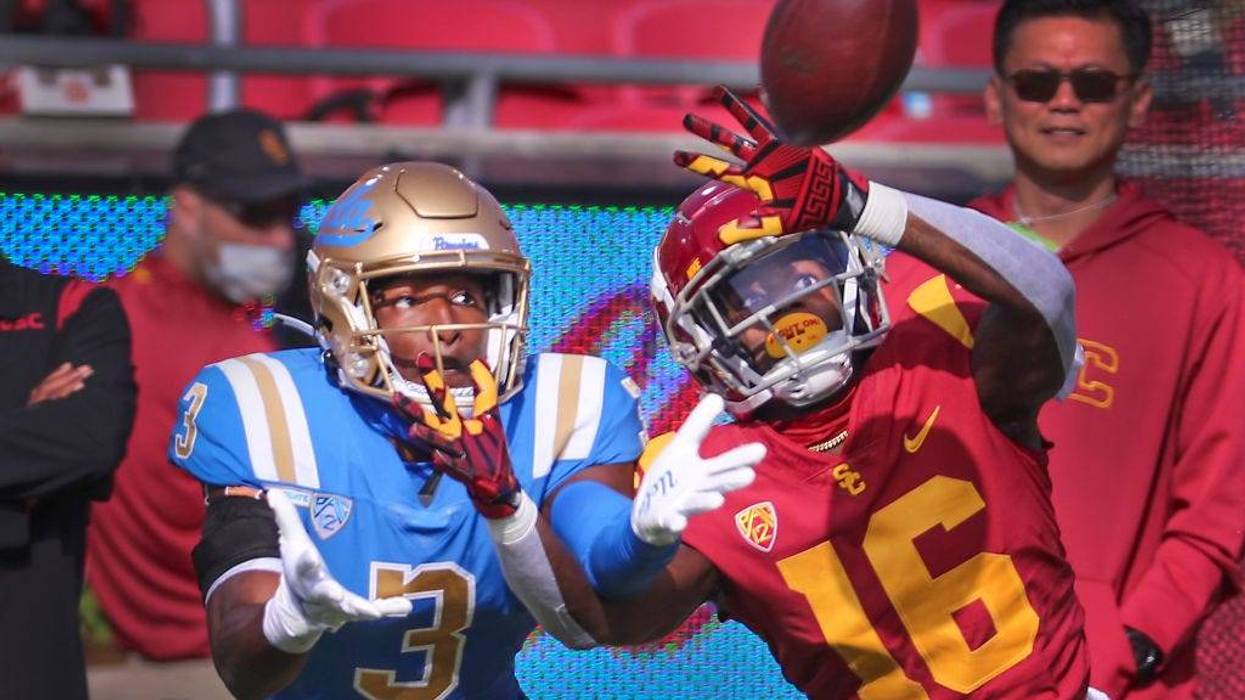 USC wide receiver That Washington, right, UCLA defensive back Cameron Johnson deflect a pass in the first quarter at Los Angeles Memorial Coliseum in Los Angeles on Saturday, Nov. 20, 2021.