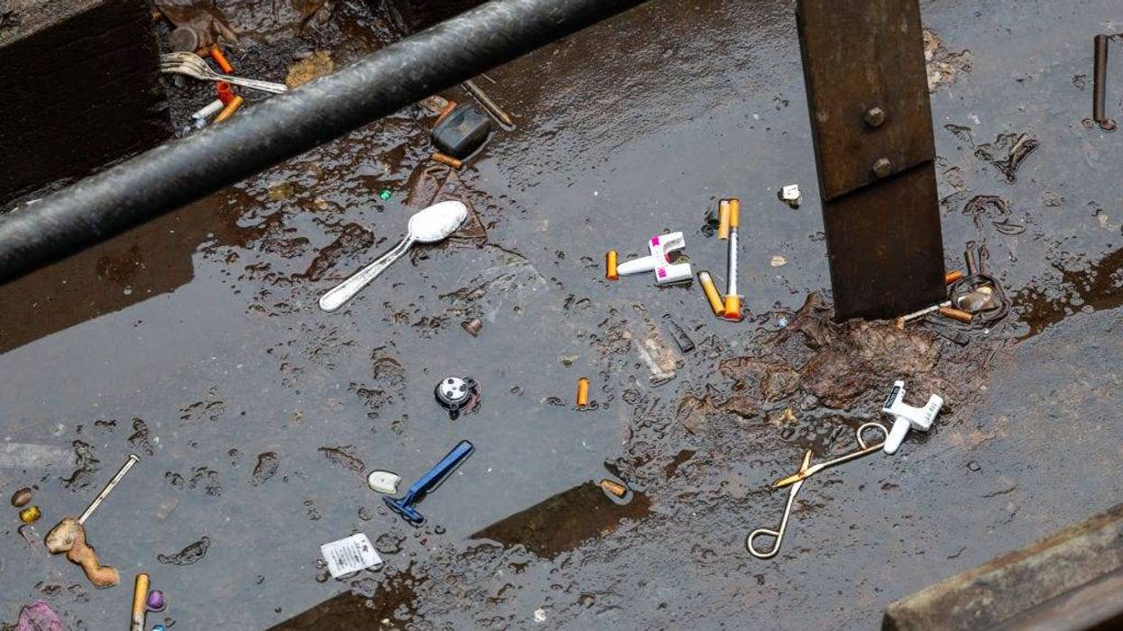 Used needles litter the ground