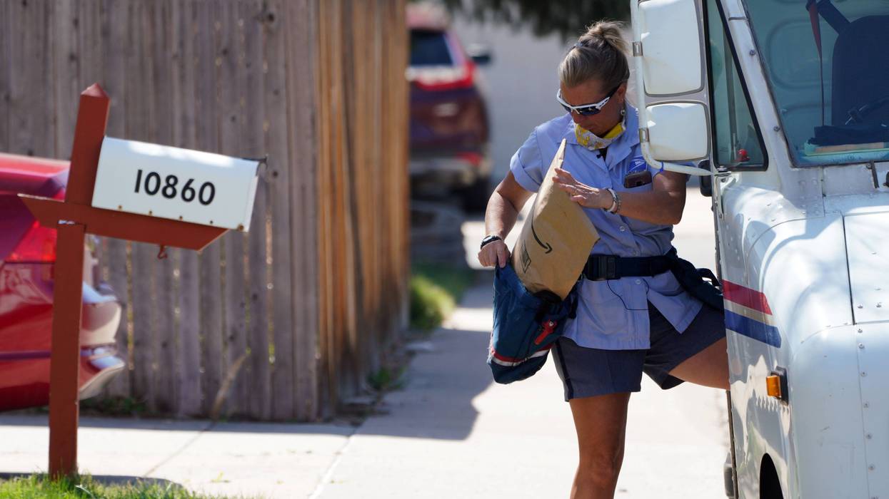 USPS carrierloads mail into her delivery pouch.