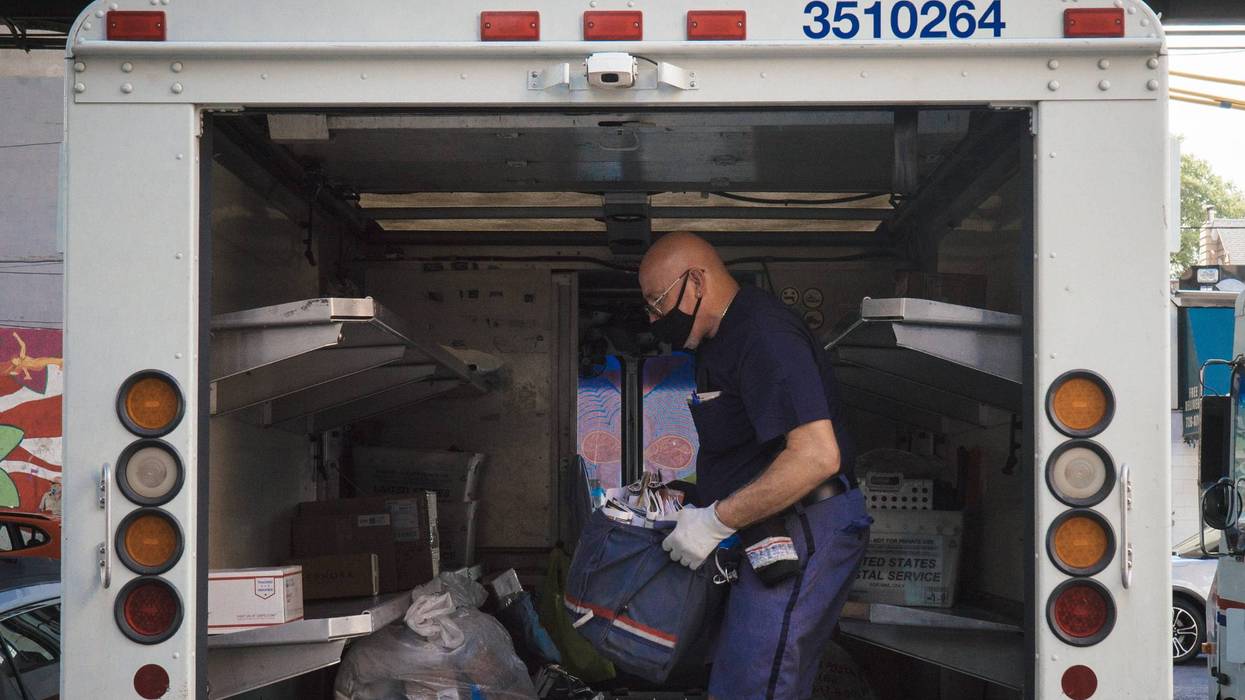 USPS postman loading mail in truck