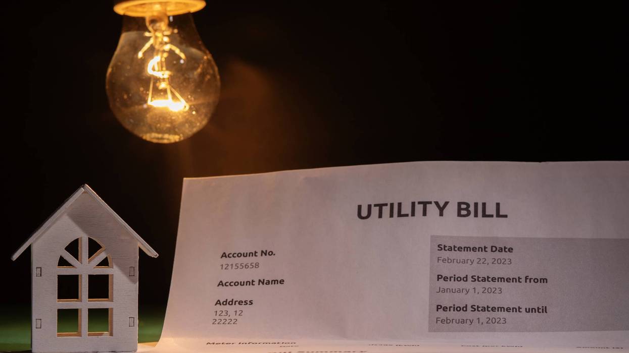 Utility bill and a house with a burning lightbulb, financial statement with cost breakdown, utility charges for electric power and heat, monthly budget planning