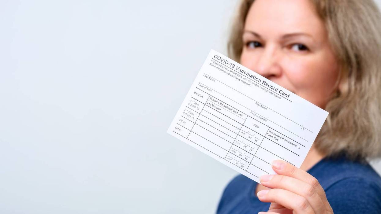 Vaccinated young woman showing COVID-19 Vaccination Record Card, happy person after getting corona virus vaccine, panoramic banner background. Concept of coronavirus vaccine shot, proof and people.