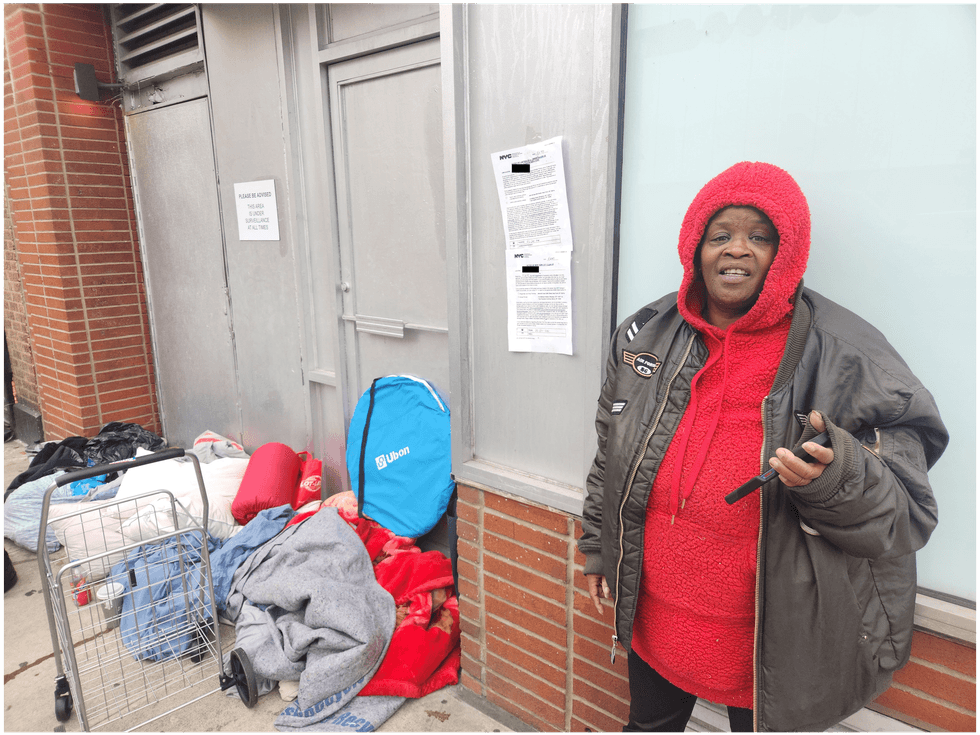 Vails stands in front of her belongings and the sign posted by the city notifying her of the coming sweep.