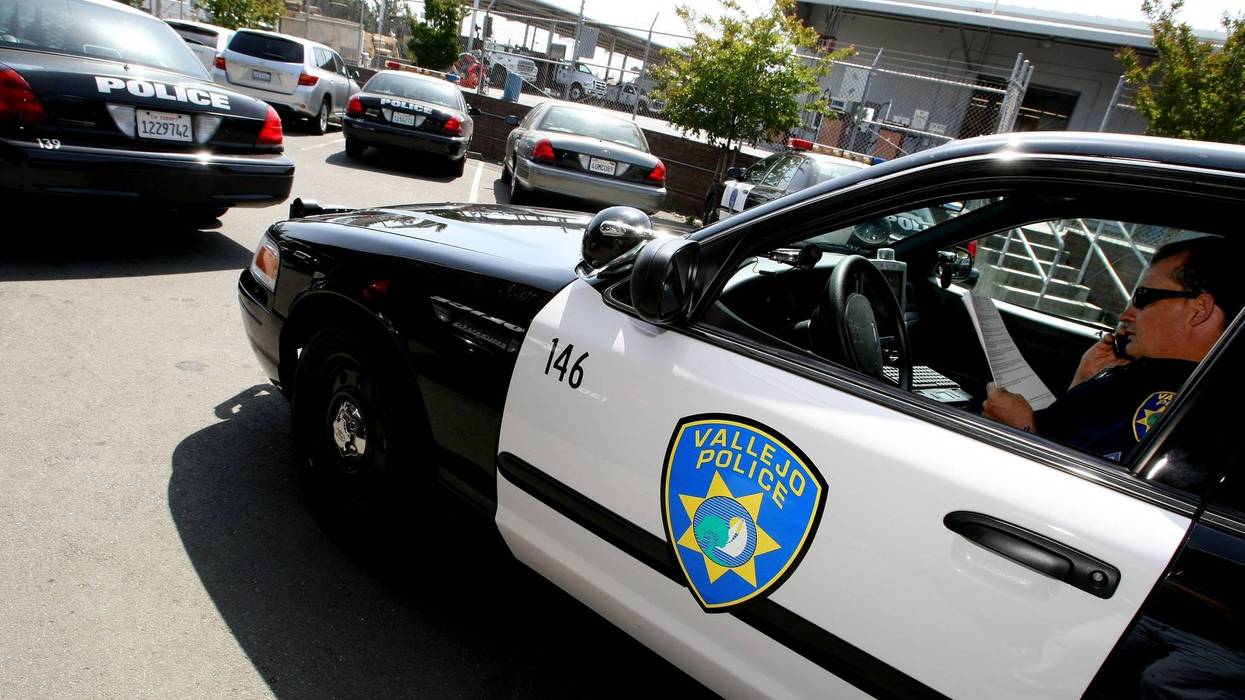 Vallejo Police Department Corporal John Garcia talks on the phone and goes over paperwork in his patrol car as he gets ready to patrol the streets May 7, 2008 in Vallejo, California.