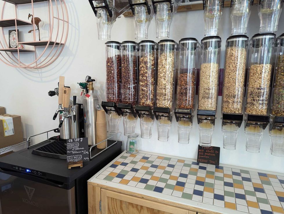 Varieties of nuts are stored neatly on the wall, under which shoppers at Eco Flamingo can place their own containers when they