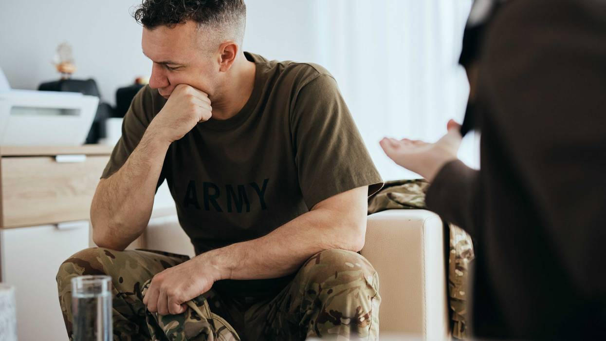 vet looking downwards, distressed, talking to a social worker