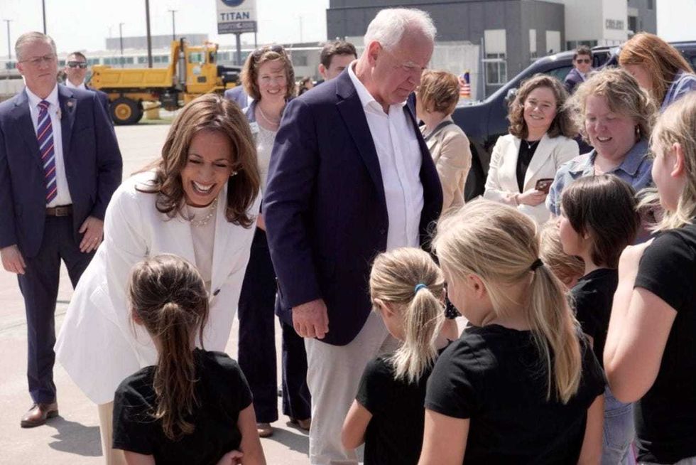 Vice President Kamala Harris and her new running mate, Minnesota Gov. Tim Walz, greet a group of children after arriving at Chippewa Valley Regional Airport in Eau Claire, Wisconsin on August 7, 2024.