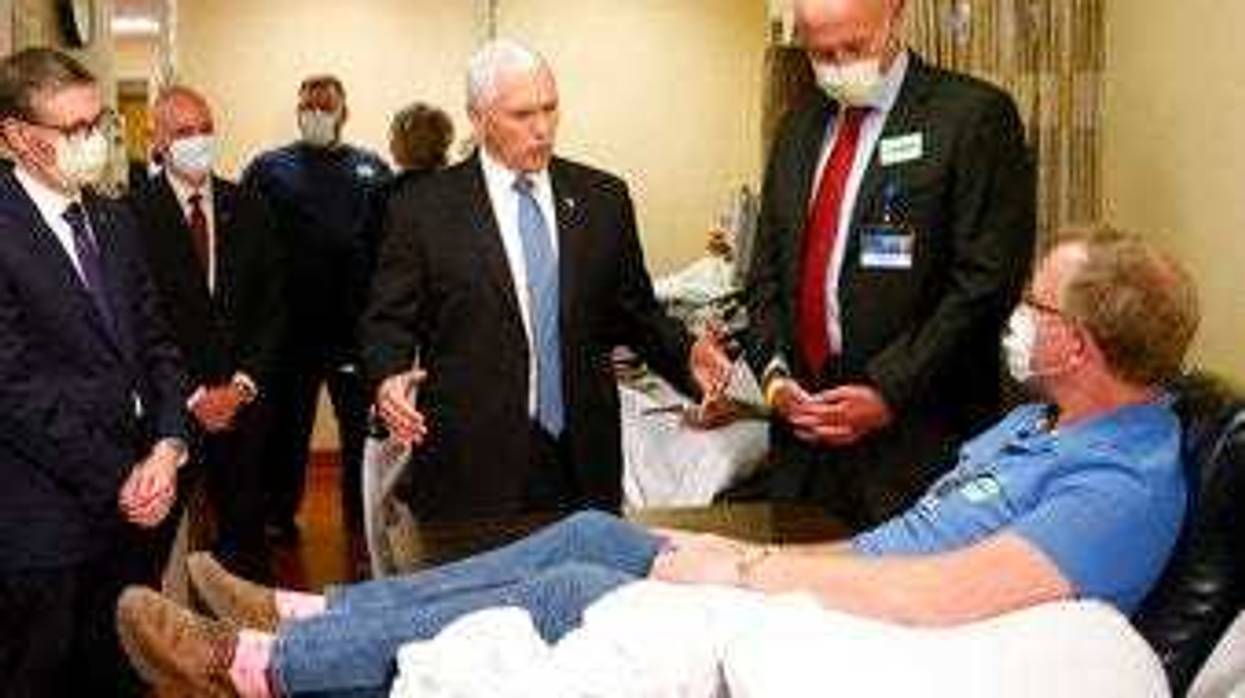 Vice President Mike Pence, center, visits Dennis Nelson, a patient who survived the coronavirus and was going to give blood, during a tour of the Mayo Clinic Tuesday, April 28, 2020. (AP Photo/Jim Mone)